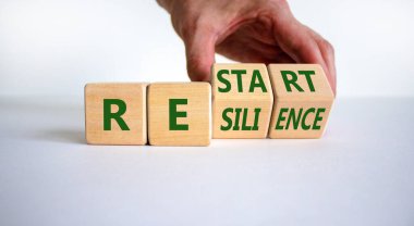 Redémarrage et symbole de résilience. une main change les cubes et transforme le mot